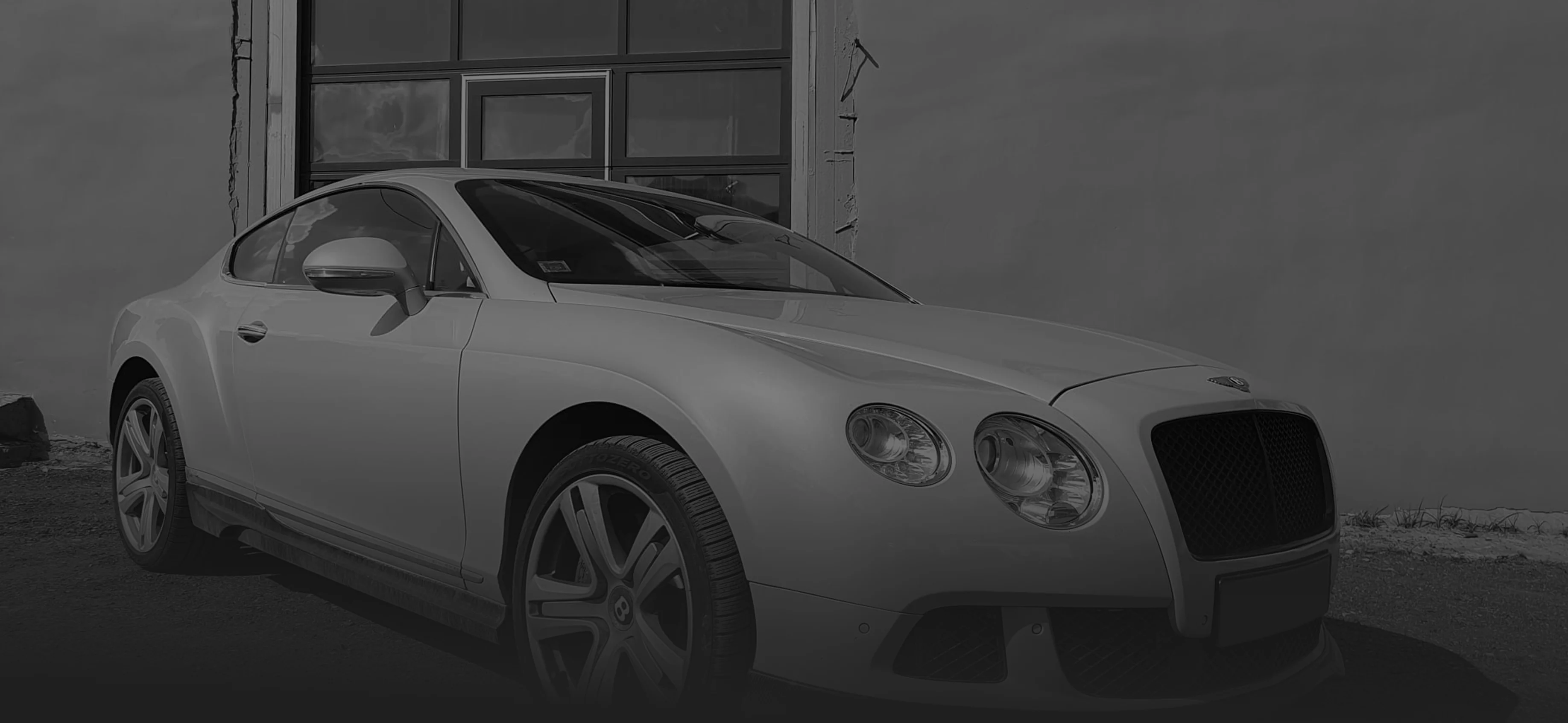 Balts Bentley Continental GT pie autoservisa ēkas